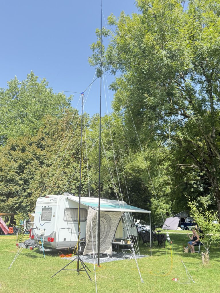 Mobile home with awning and antenna mast on the campsite