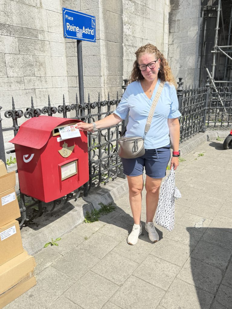 Posting a card at a red letterbox in Dinant